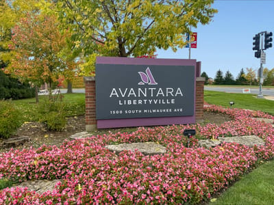 Facility sign among flowers and greenery