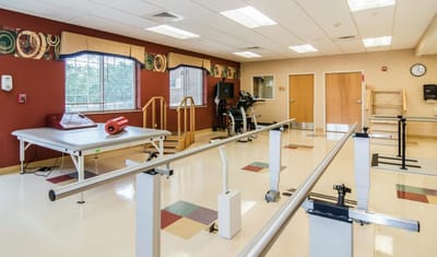 Physical therapy room with equipment and exercise bars
