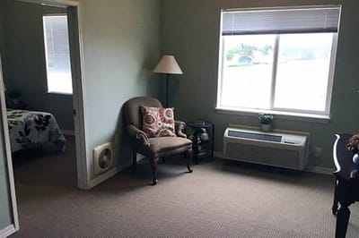Cozy interior of a resident's room with a chair and window