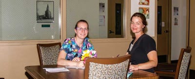Two staff members engaged at a table in the facility