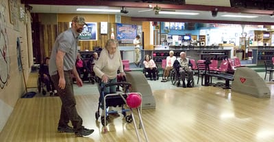 Residents participating in bowling activity indoors