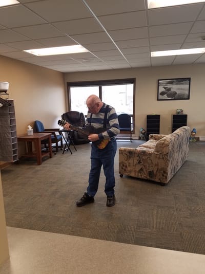 Resident playing guitar in a common area