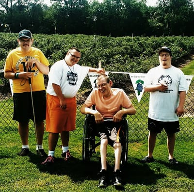 Group of four individuals at an outdoor event in a garden