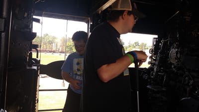 Two individuals exploring inside a train engine.