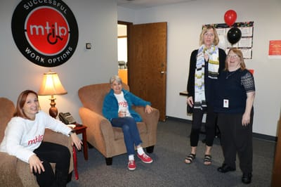 Facility logo displayed in a common area with staff and residents