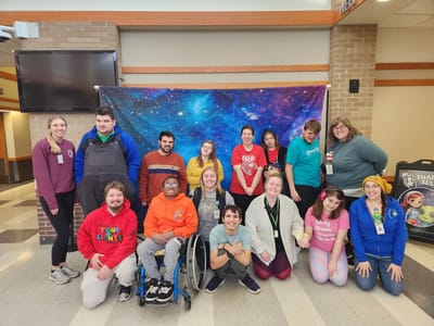 Residents and staff posing together in a colorful common area