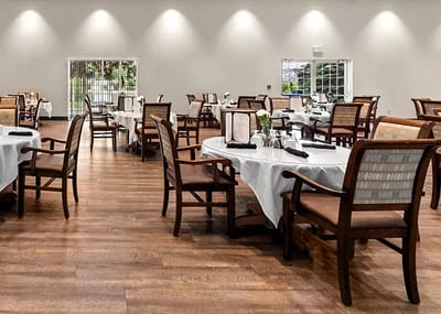 Dining area with tables and chairs set for residents