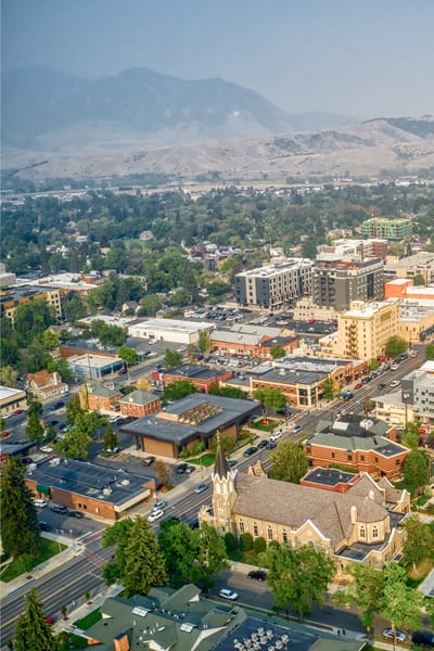 Aerial view of a town with buildings and mountains.