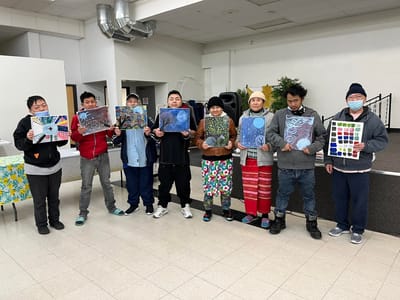 Residents showcasing their artwork in an activity room