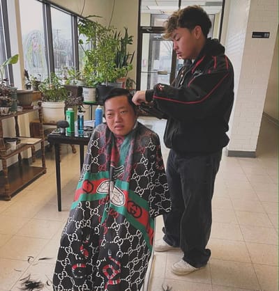 Resident receiving a haircut in a facility common area