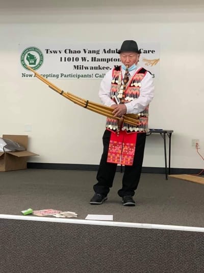 Resident performing with a traditional instrument during an activity