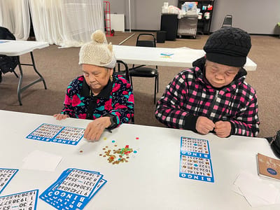 Residents playing bingo at a brightly lit activity room