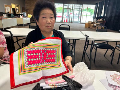Resident showcasing handmade craftwork in a social setting