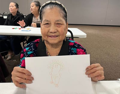 Resident showing their artwork in an activity space
