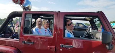 Residents enjoying a ride in a red vehicle