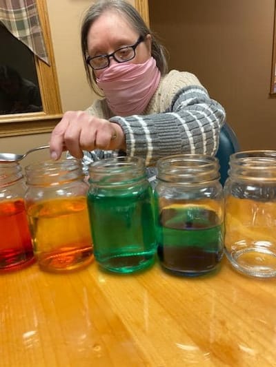 Resident engaging in a colorful activity with jars