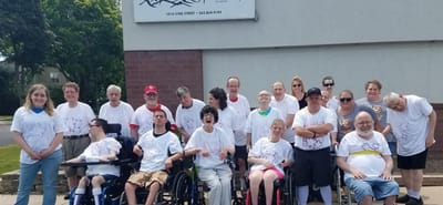 Group of residents and staff in matching t-shirts outdoors