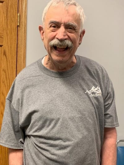 A smiling resident in a gray t-shirt