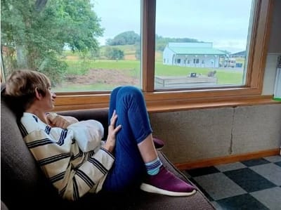 Resident relaxing by a window with outdoor view