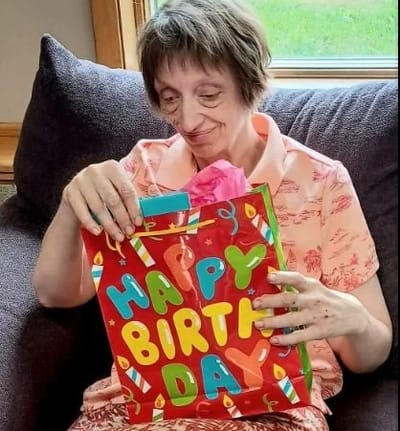 Resident opening a birthday gift in a cozy setting