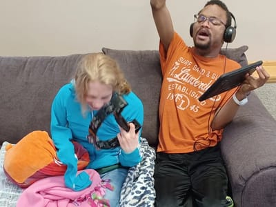 Residents enjoying music and having fun on a couch