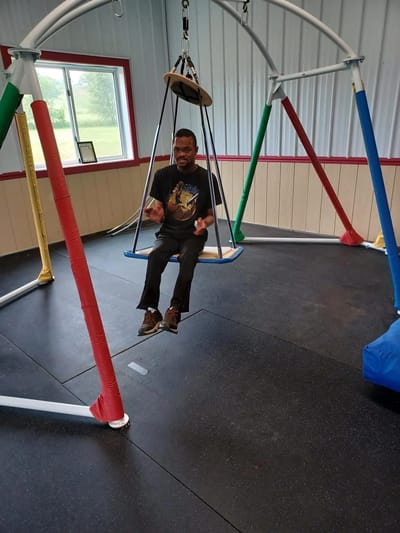 A resident enjoying a swing in an activity room
