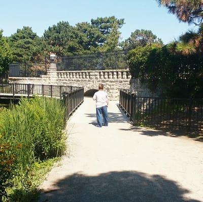 A person walking on a pathway in a garden setting