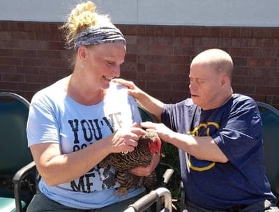 Residents interacting with a chicken outdoors