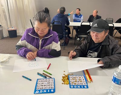 Residents engaging in a bingo activity at a table