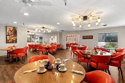 Cozy dining room with red chairs and wooden tables
