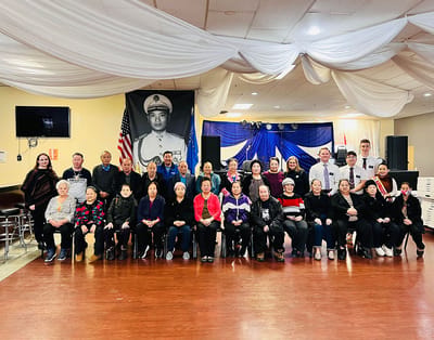 Group photo of residents and staff celebrating in a common area