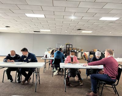 Residents and staff engaged in an art activity at a long table
