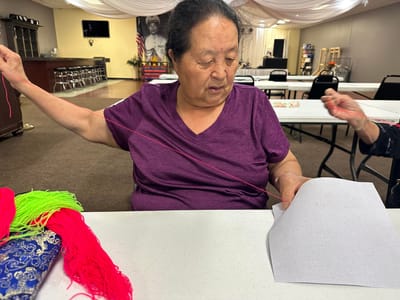Resident engaged in a hands-on activity with yarn.