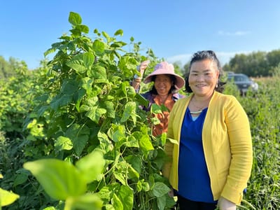 Two women gardening in a lush outdoor space