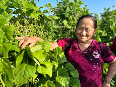Senior resident smiling among green plants