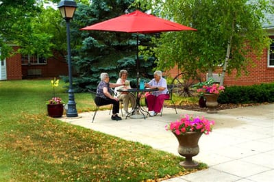 Residents enjoying time outdoors under a red umbrella