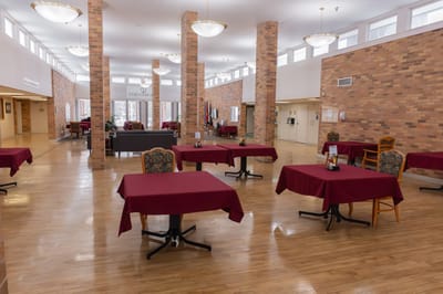 Dining area with tables and chairs in a senior living facility
