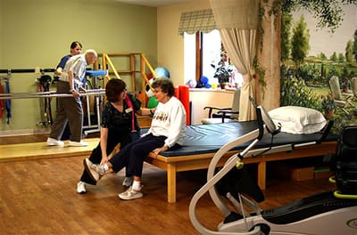 Therapist assisting resident in rehabilitation activity