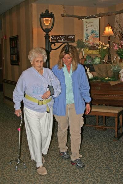 Staff assisting a resident in a cozy interior setting
