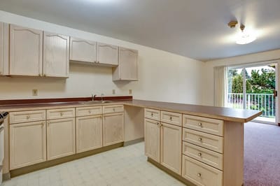 Bright kitchen area with light cabinetry and access to a balcony