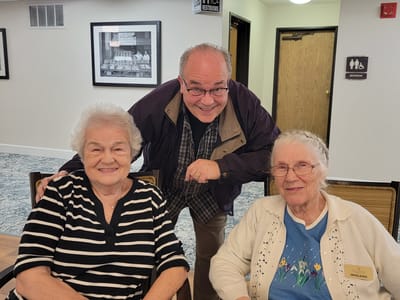 Residents enjoying time with a staff member in a common area