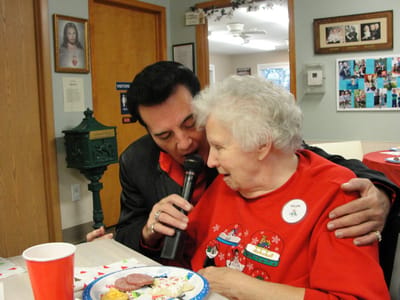 A resident enjoying a performance with a staff member