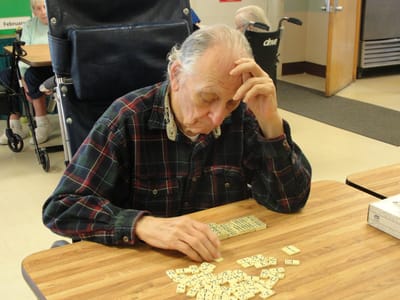 Resident playing dominoes in a common area