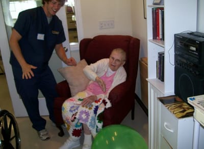 Staff member engaging with a resident in a cozy interior