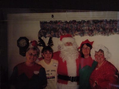 Residents and staff dressed for a holiday celebration with Santa
