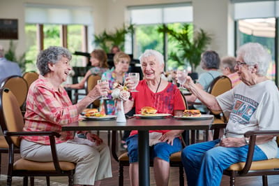 Residents enjoying a meal and drinks together in the dining room