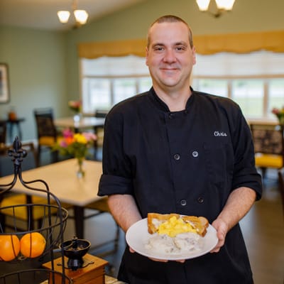 Staff member presenting a meal in a dining area