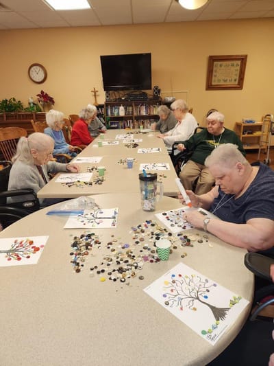 Residents engaging in a creative activity at a well-lit table