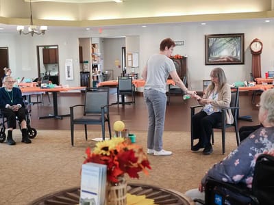 Staff member assisting a resident in an activity room