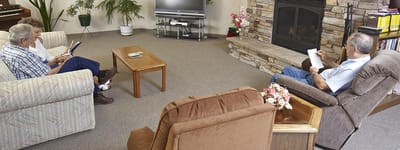 Residents enjoying time in a common area with a fireplace